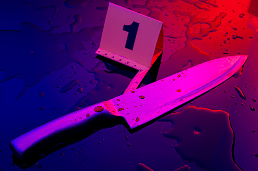 bloody crime scene knife lit by cop car lights