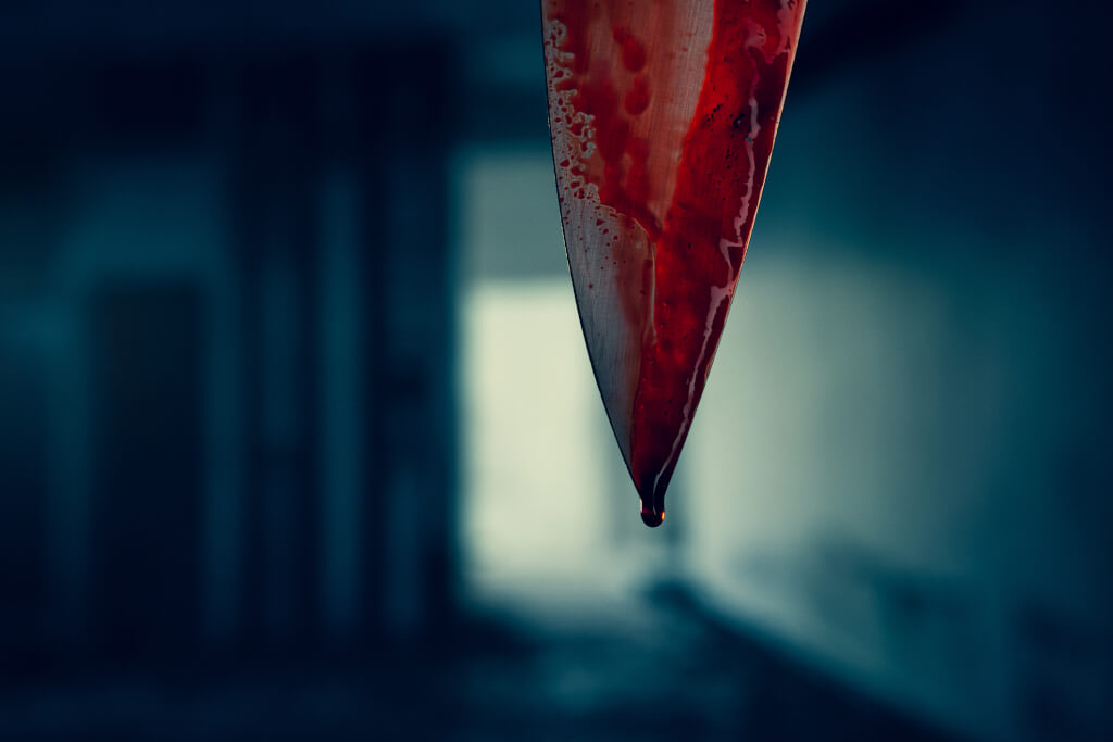 Close up of knife blade with dropping blood