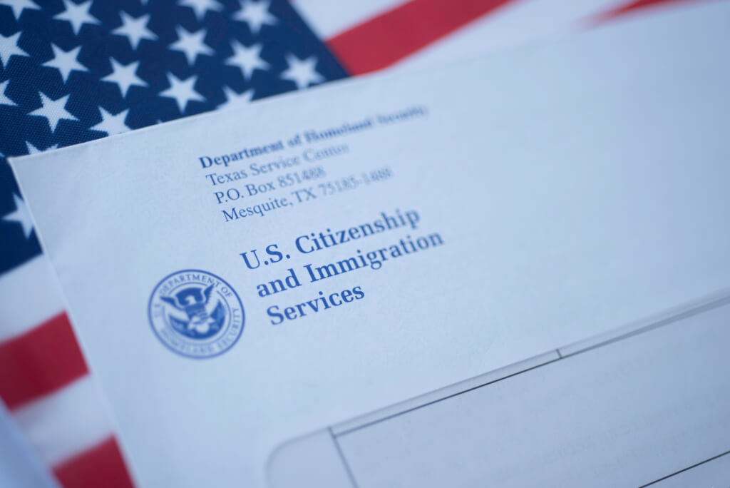 ბუნდოვანი წერილი (კონვერტი) USCIS-დან აშშ-ს დროშაზე