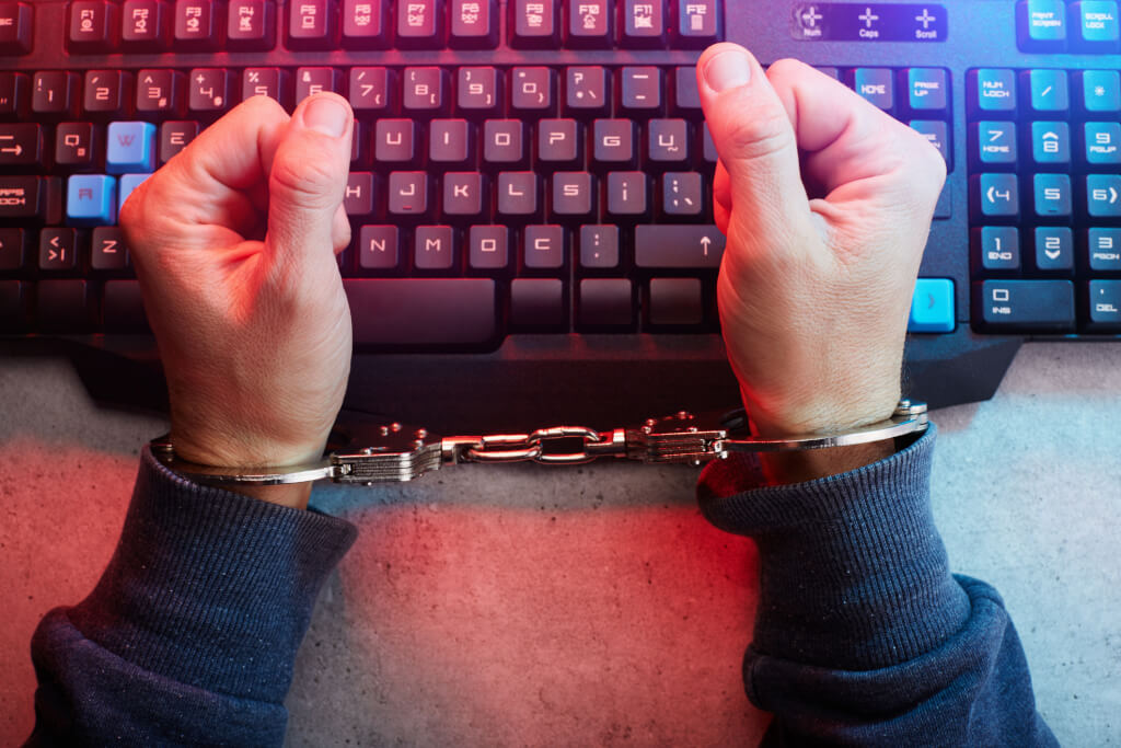Handcuffed person on computer keyboard