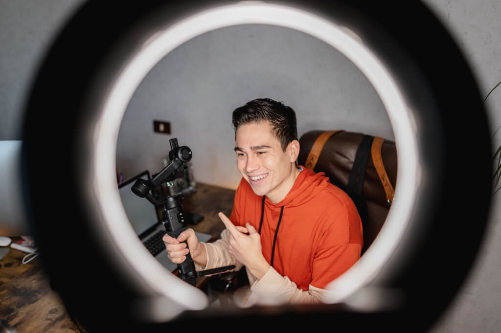 A young social media influencer filming an informative video blog on camera with perfect lighting for online followers