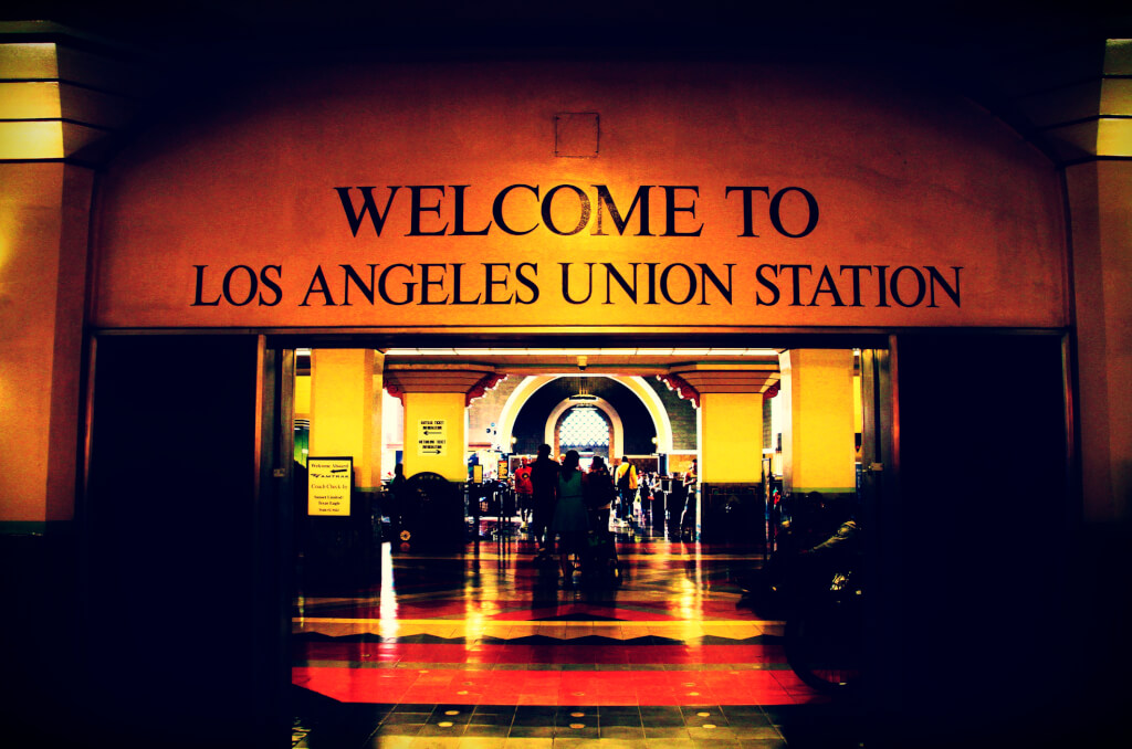 Passengers walking or sitting on chairs inside Union Station in Los Angeles, California