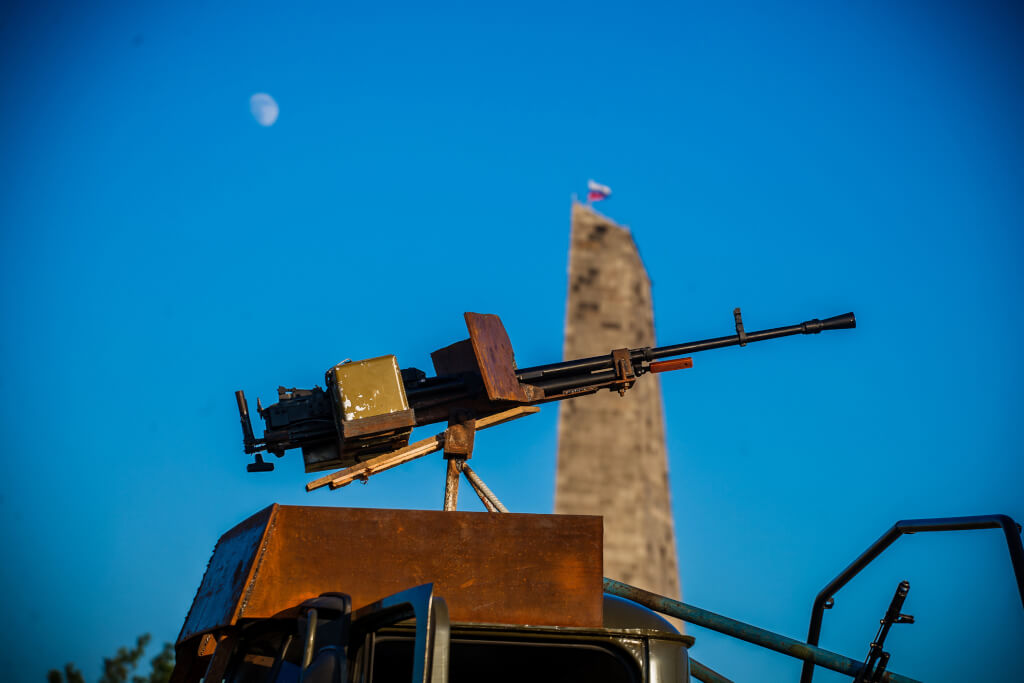 Аймен күндізгі аспан фонында пулемет