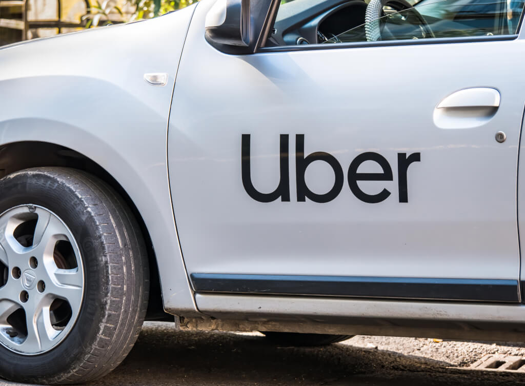 Uber logo inscriptioned on a white painted car