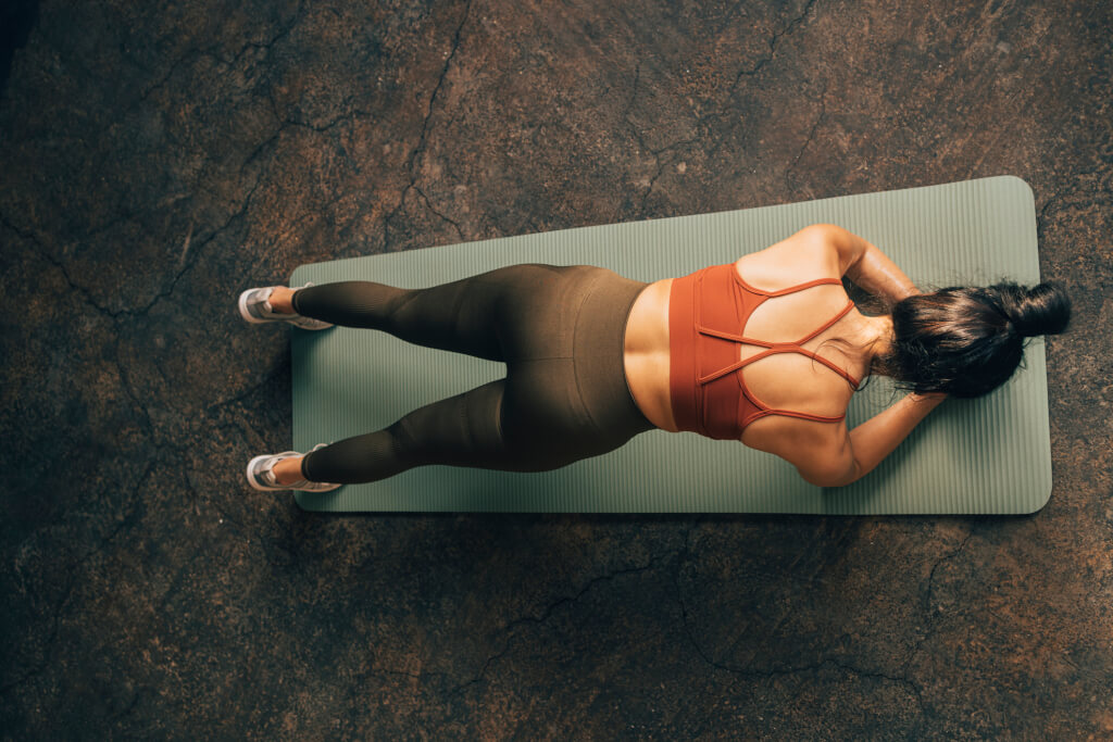 woman holding a plank position on a yoga mat.
