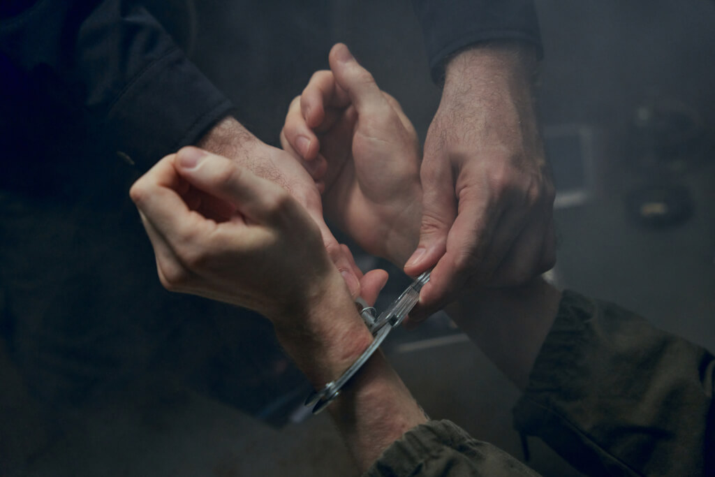 Close-up of putting on handcuffs on hands of criminal