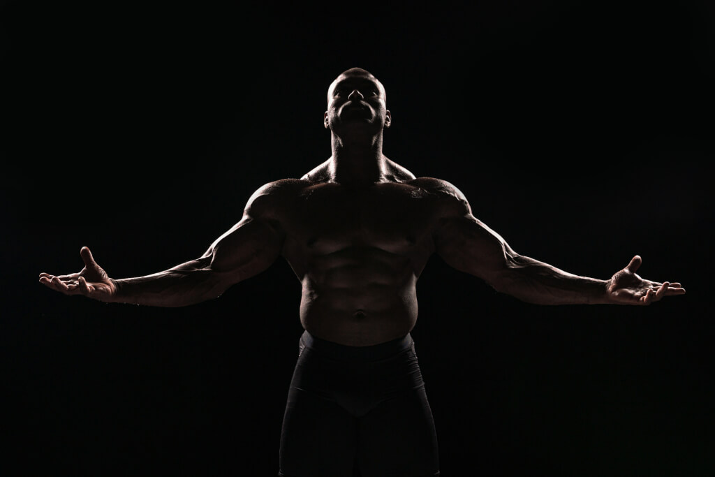 Жорсткий bodybuilder показує його muscle photograph в студії portrait setting