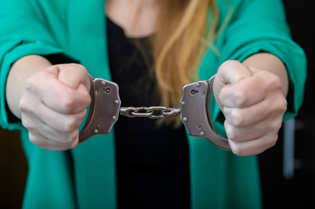 Blonde woman in police handcuffs, criminal