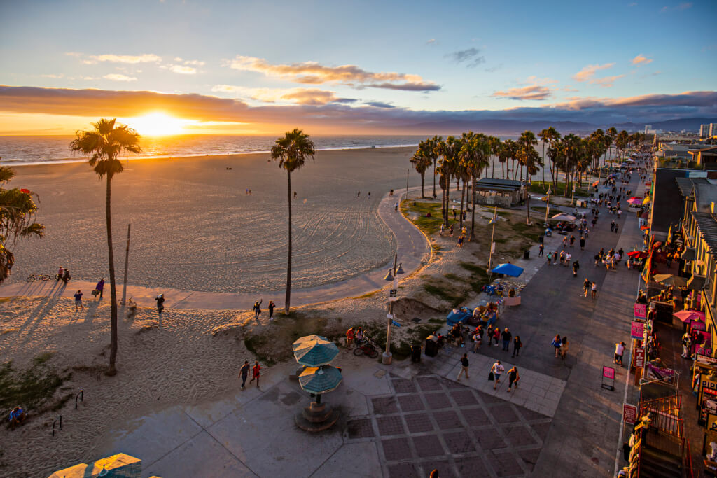 High angle view of Venice beach during sunset. Tourists walking on footpath by beach during sunset